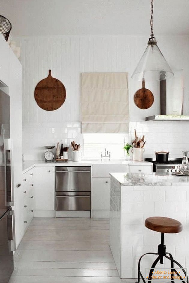 A small kitchen in white color with a pencil case and a bar counter