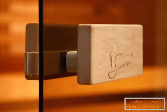 Stylish fittings for glass doors in the sauna - a handle made of wood