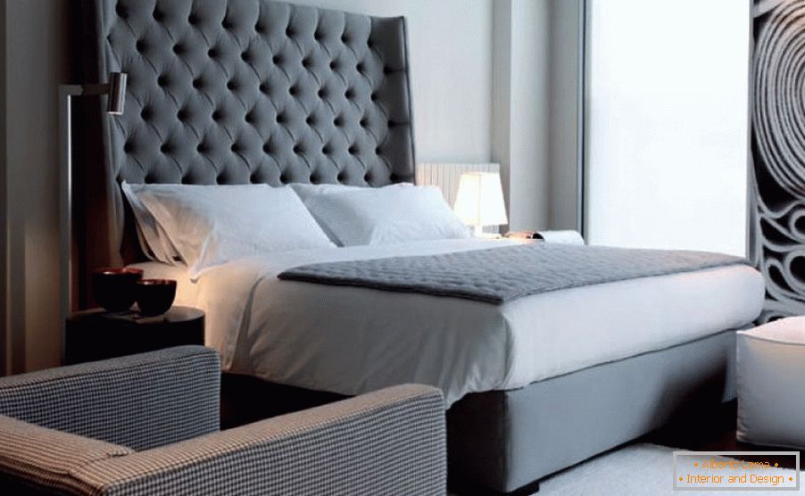 A large bed with a high headboard