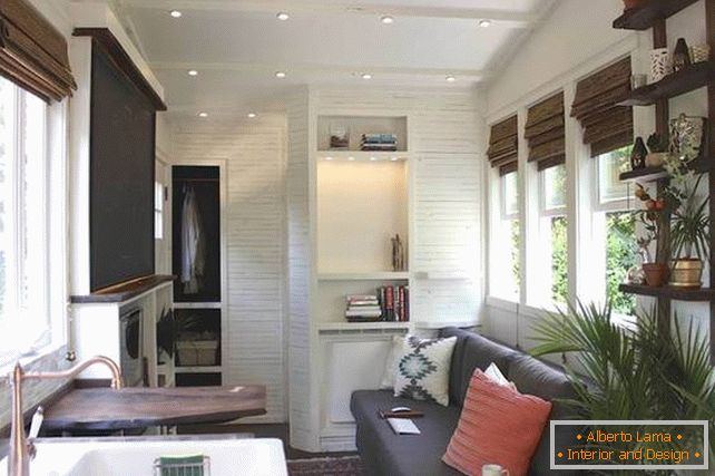 A small house on wheels with a luxurious bed and kitchen